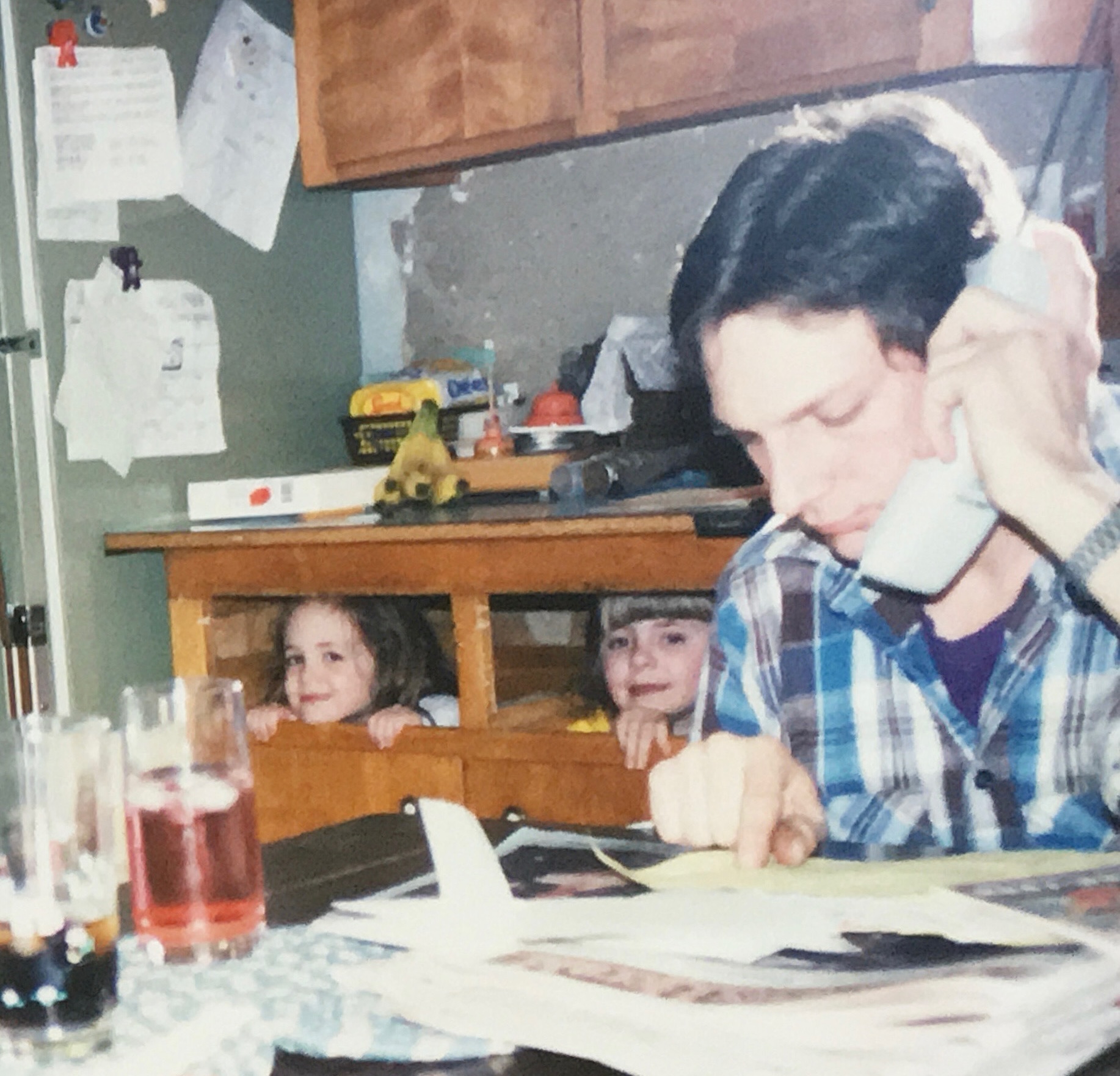 Dan working, with his two kids hiding in the background.